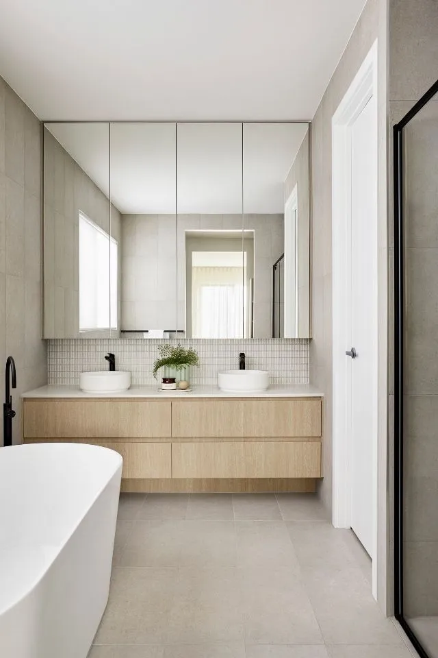 Moderne badkamer met dubbele wastafel, houten badkamermeubel en vrijstaand bad